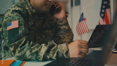 African American army officer talking on phone in office, controlling operation photo