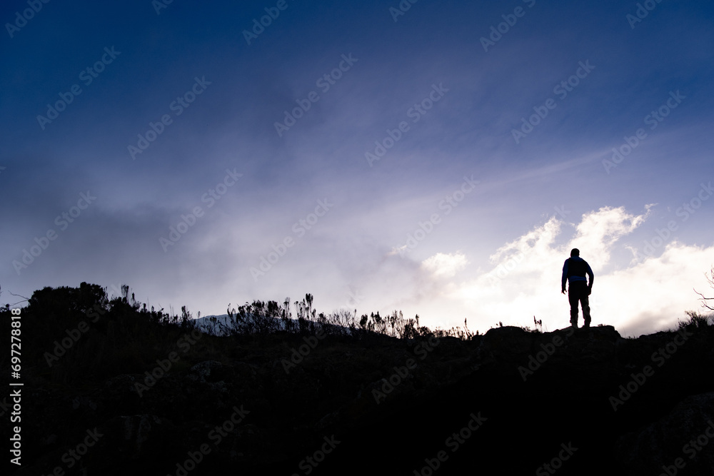 Man watching sunrise on Kilimanjaro