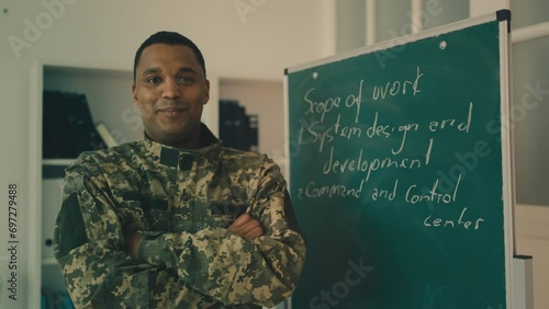 Portrait of smiling African American military academy teacher near chalkboard photo