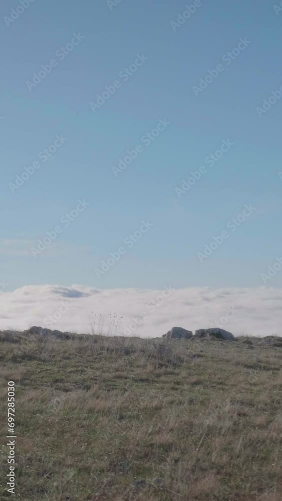 Young caucasian woman in sunglasses with long hairs is jogging above clouds. Vertical Video Young caucasian woman in sunglasses with long hairs is jogging above clouds. Vertical Video