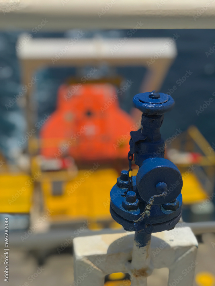 Fototapeta premium closeup view of valve with free fall life boat in the back ground