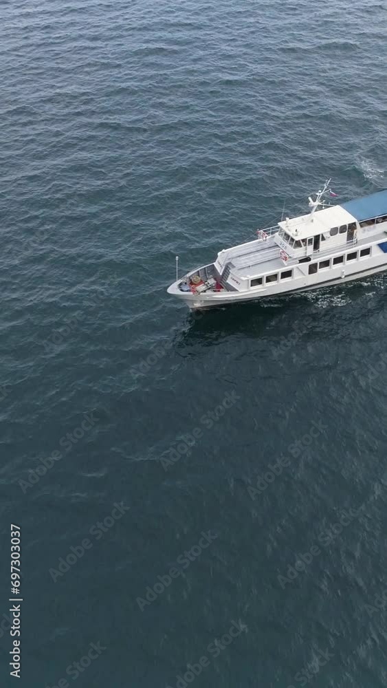 Small white cruise ship is sailing in sea. Drone is surveying ship. Vertical Video Small white cruise ship is sailing in sea. Drone is surveying ship. Vertical Video