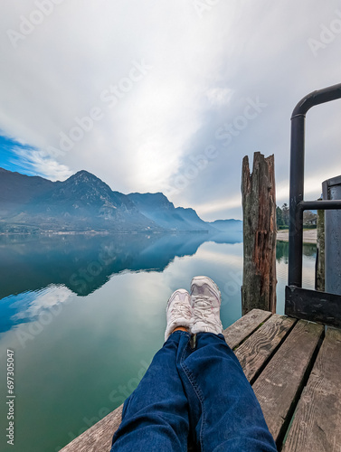 photo on the phone.
woman resting near an alpine lake in the mountains. photo without a face.