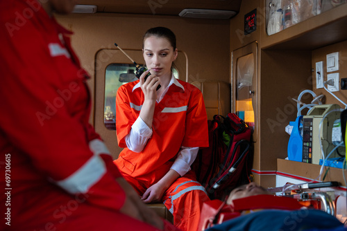 rescue nurse holds a walkie-talkie wearing a uniform and rushes to help a patient who has been in an accident. The team helps CPR the injured person and uses a life support machine in the ambulance. photo