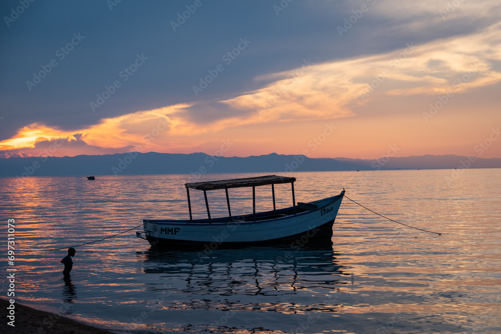 Boy and boat in the evening light in Cape Maclear, Malawi