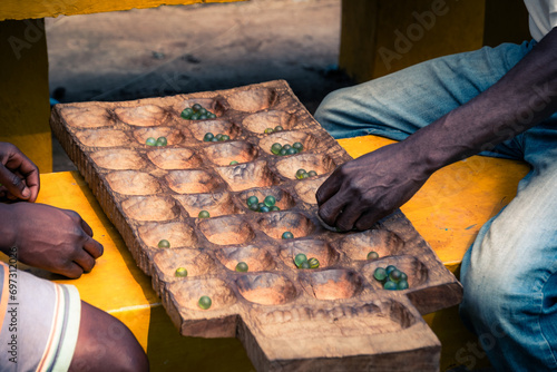 Men playing Awele in Zomba, Malawi