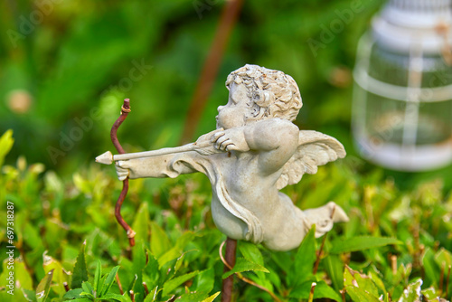 Fototapeta Naklejka Na Ścianę i Meble -  Funny cupid figure as garden decoration.