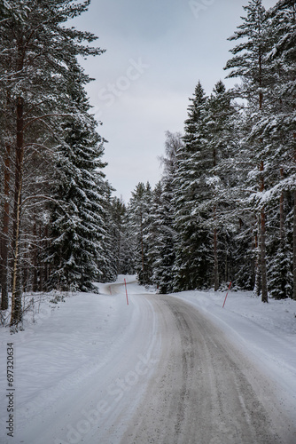 Great snowy winter landscape. A road through a snow-covered pine and spruce forest. Cold winter landscape in Sweden