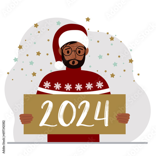 A man in a Christmas red hat with snowflakes holds a Happy New Year 2024 card.