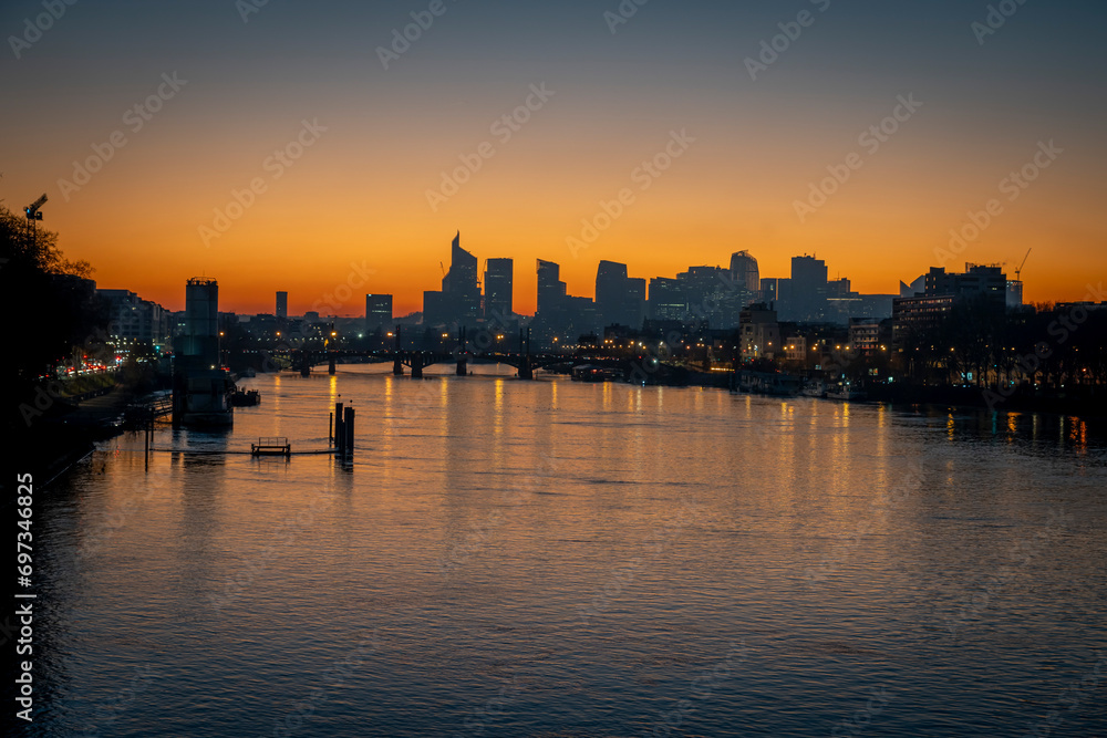 Gennevilliers, France - 12 17 2023: Panoramic view of the Seine river and La Defense towers district from Clichy bridge at sunset.