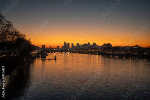 Gennevilliers, France - 12 17 2023: Panoramic view of the Seine river and La Defense towers district from Clichy bridge at sunset.