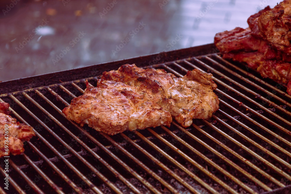 Food in a large round pan and grill placed on the counter and intended for sale in the market to customers.