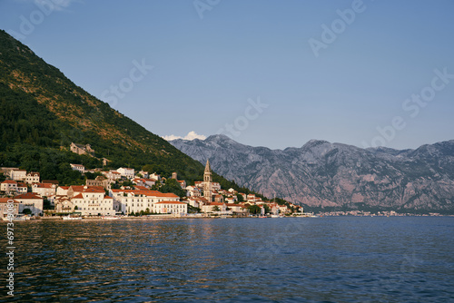 Bell tower of the church of St. Nicholas in Perast among old houses with red roofs. Montenegro