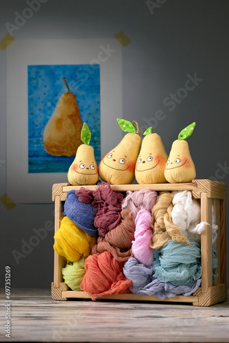 Pear family of father, mother and children on a wooden box with colorful fabrics