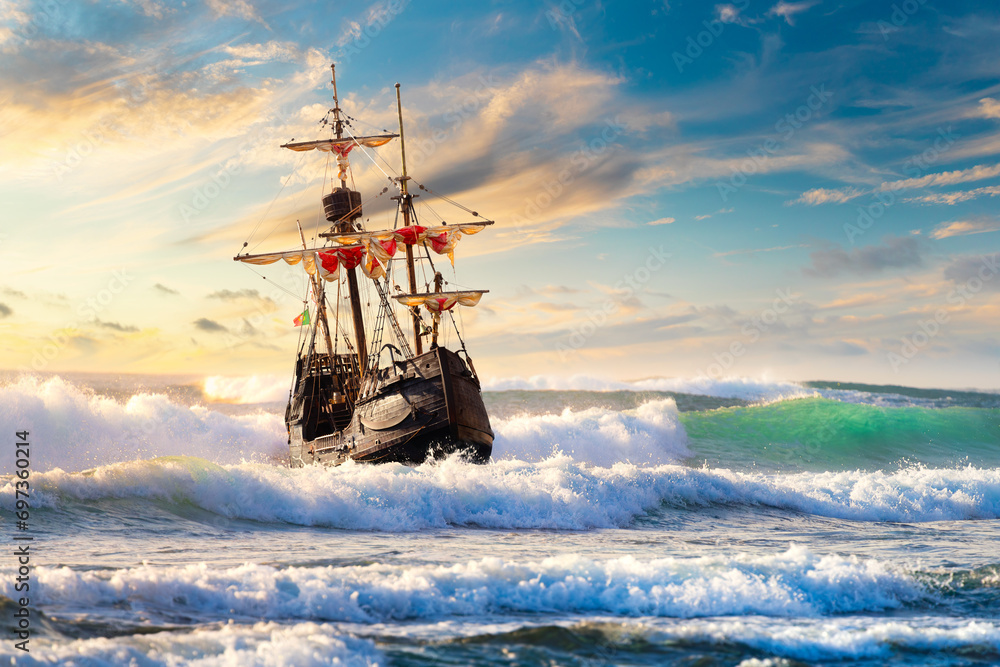 Grand view of an old sailing ship from the times of pirates and the Middle Ages on the high seas with big waves and with a beautiful sky