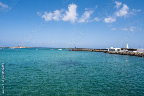 View of the Fermina islet. Turquoise blue water. Sky with big white clouds. Seascape. Lanzarote  Canary Islands  Spain.