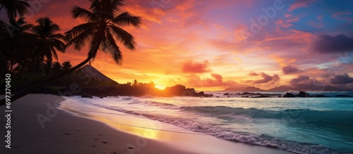 Spectacular sunrise photo on tropical beach with colorful sky and mountain silhouette.