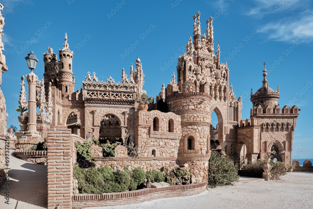 Castillo de Colomares Benalmadena, Malaga, Spain framed by a stone arch with a view to ornate turrets and ramparts