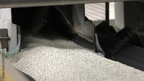 Conveyor belt for transporting powdery white granular phosphorus fertilizer. Warehouse for storing white granulated phosphate fertilizers. 
