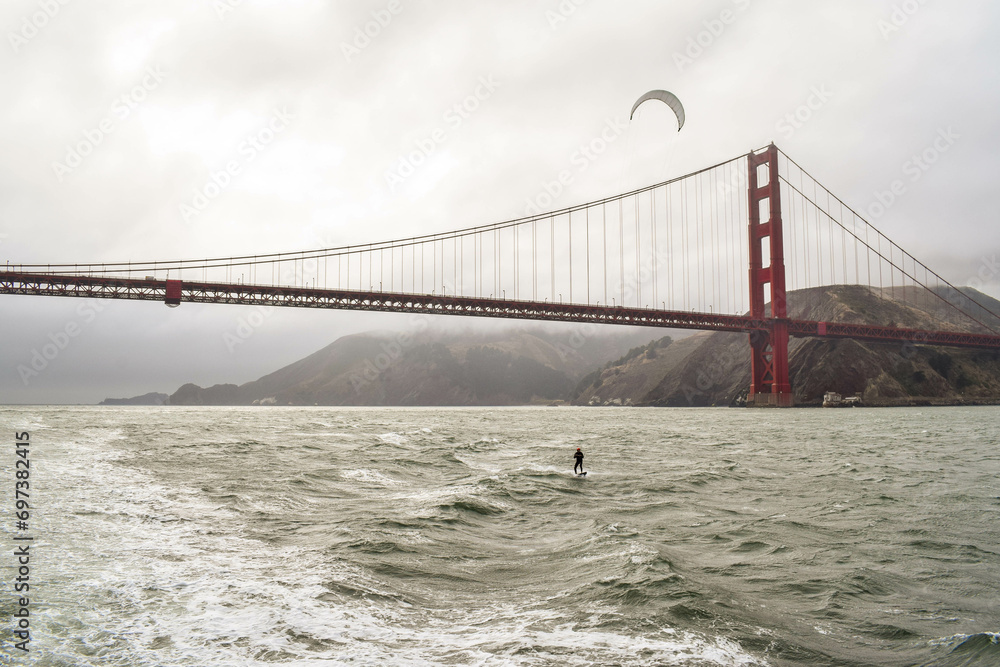 kite surfer under golden gate bridge, san francisco, california kite surfer under golden gate bridge, san francisco, california