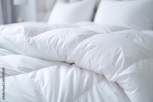 white duvet lying on the background of the headboard with pillows,close-up,the concept of preparing for the winter season,household chores,comfort in the house,hotel and home textiles photo