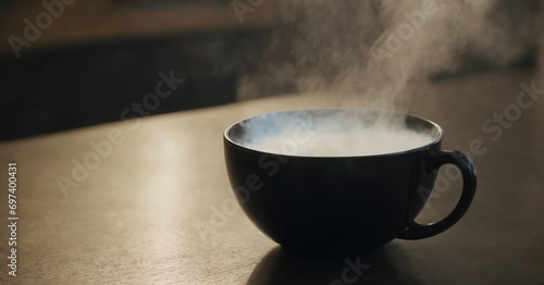 A captivating photo showcasing hot steam rising from a black mug, creating a swirling motion in the air against an isolated background.