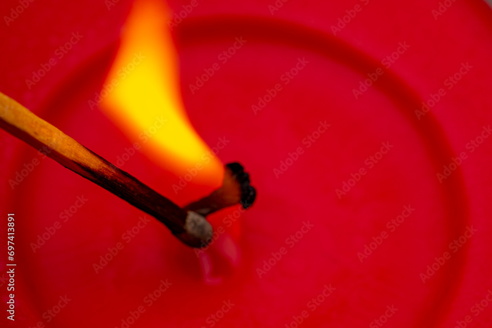 red wax candle with burning flame
