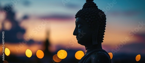 Buddha silhouette against a blurred evening sky. photo