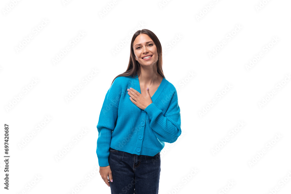 young positive cute brunette woman dressed in a blue cardigan on a white background with copy space young positive cute brunette woman dressed in a blue cardigan on a white background with copy space