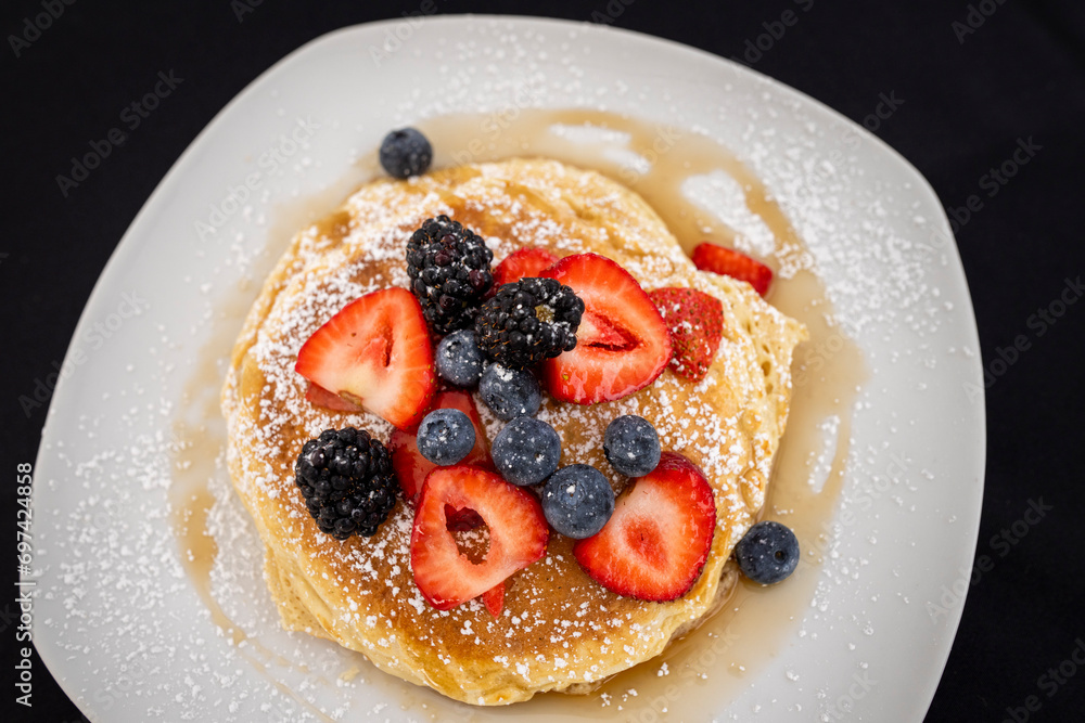 Stack of pancakes on a plate with fresh blueberries and strawberries
Stack of pancakes on a plate with fresh blueberries and strawberries