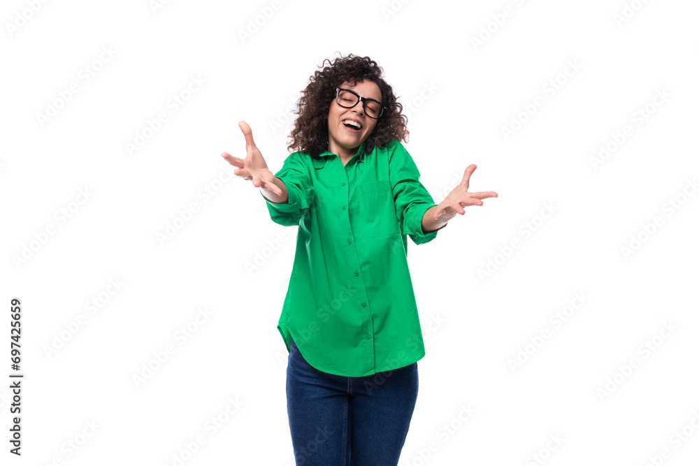 brunette young caucasian lady with curly hair with glasses dressed in a green shirt on a white background with copy space brunette young caucasian lady with curly hair with glasses dressed in a green shirt on a white background with copy space