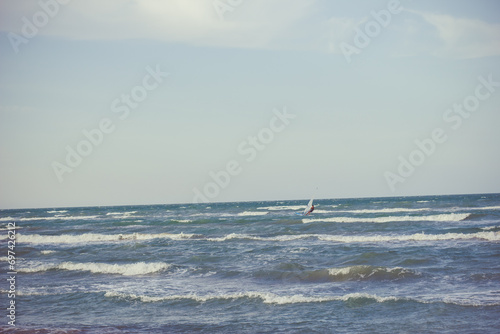A sailboat floats on the waves of a stormy sea