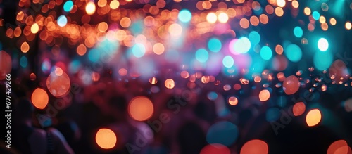 Create a blurry and defocused texture. Illuminate colored lights during a concert with artists performing amidst light and smoke.