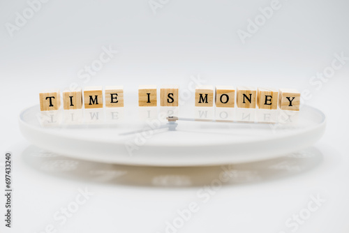 A clock with ‘Time is money’ written on it in wooden letter cubes