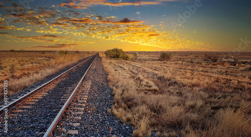 Peaceful sunrise over a vast open field with railroad tracks. space