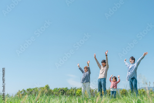 空と高原・草原・公園でバンザイするアジア人の三世代家族・親子・ファミリー（女の子）
 photo