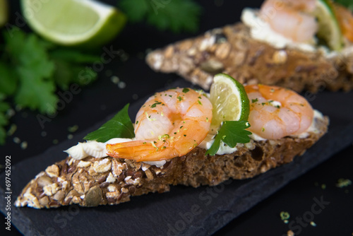 Delicious wholemeal bread crostini with prawns, spreadable cheese and lime