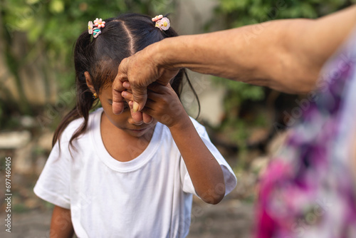 A respectful young girl does the mano po gesture to his grandmother. A sign of respect and reverence to your elders in the philippines.