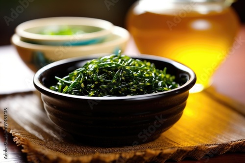 In this vibrant food shot, a small bowl is filled to the brim with thin, flavorful seaweed strips, their deep green hue beautifully contrasting against the smooth, porcelain dish.