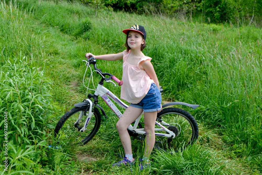 Young girl cyclist enjoy the beautiful sunrise on summer forest trail Young girl cyclist enjoy the beautiful sunrise on summer forest trail