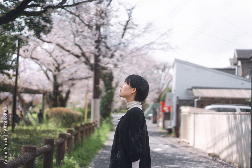 Side view japanese woman closing eye with sakura flower tree in Tokyo city japan spring season
