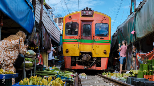 Maeklong Railway Market Thailand, tourist taking photos with mobile of the Fresh Market on the Railroad Track Mae Klong Train Station Bangkok 