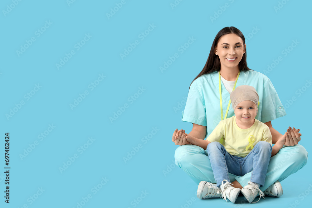 Little girl after chemotherapy with nurse sitting on blue background. Childhood cancer awareness concept Little girl after chemotherapy with nurse sitting on blue background. Childhood cancer awareness concept