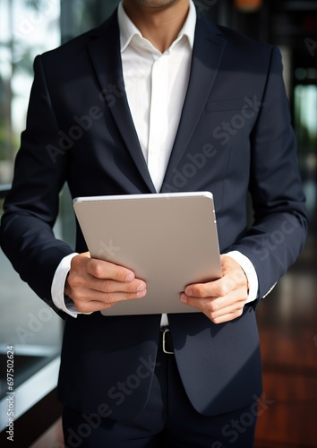 Cropped shot of young businessman working on his project while using digital tablet in modern office room