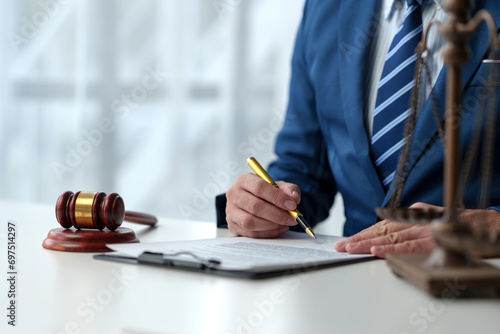 Consultant or lawyer and scales, hammer of justice read contract details before signing to check details, correctness of recorded information. Justice concept.