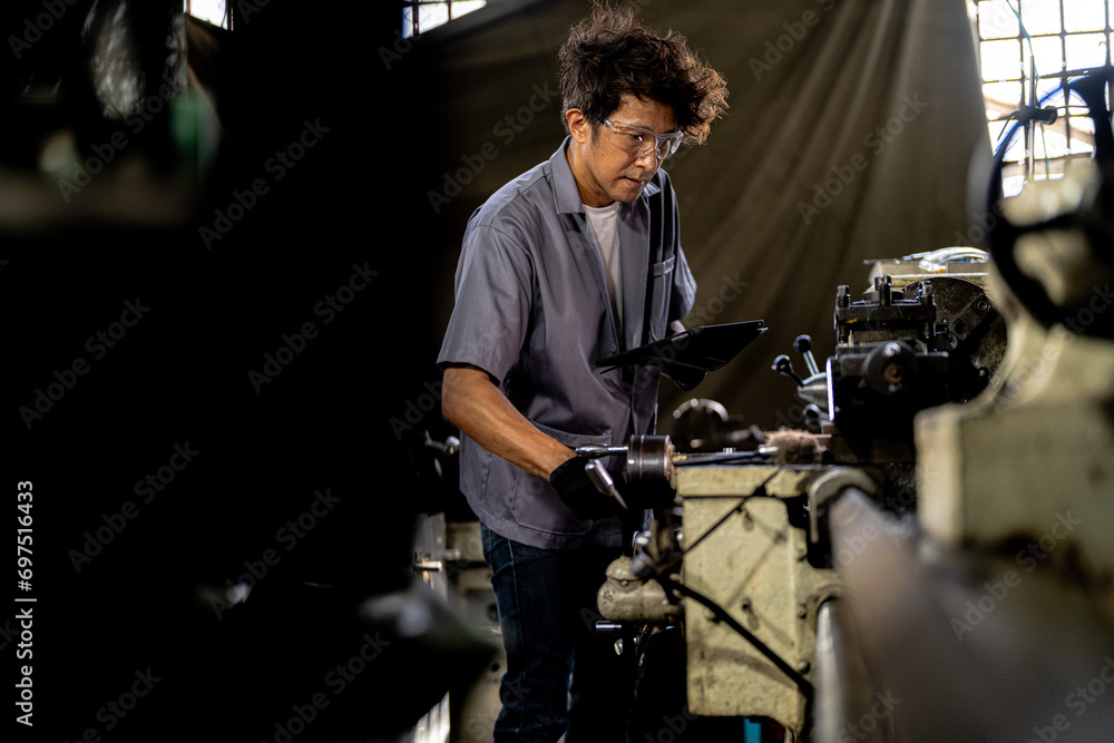 Asian worker in production plant drilling at machine. Professional worker near drilling machine on factory. finishing metal working internal steel surface on lathe grinder machine with flying sparks. Asian worker in production plant drilling at machine. Professional worker near drilling machine on factory. finishing metal working internal steel surface on lathe grinder machine with flying sparks.