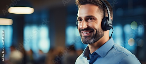 Closeup of a male technical customer support operator using a headset in an office.