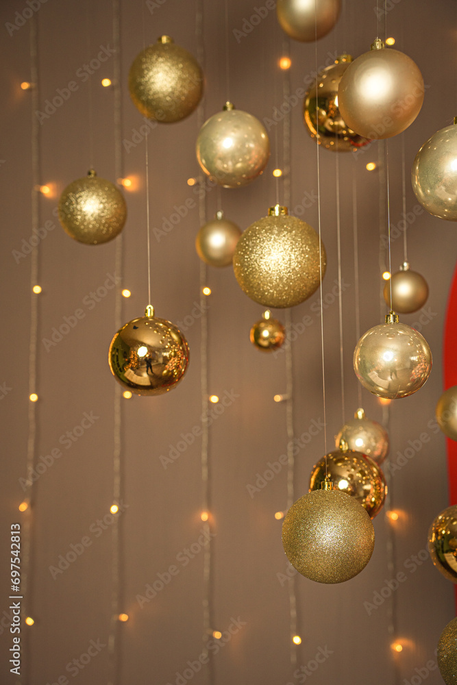 New Year's golden balls hanging on strings on background with mirror in the form of a large window New Year's golden balls hanging on strings on background with mirror in the form of a large window