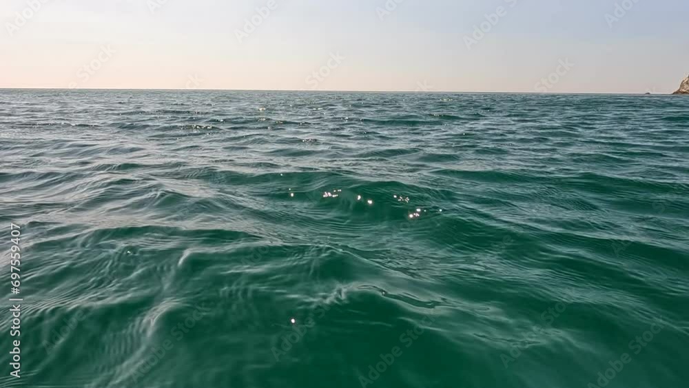 Sea water surface. Low angle view from kayak, camera flies over the clear green sea water. Nobody. Holiday recreation concept. Abstract nautical summer ocean nature. Slow motion. Close up Sea water surface. Low angle view from kayak, camera flies over the clear green sea water. Nobody. Holiday recreation concept. Abstract nautical summer ocean nature. Slow motion. Close up