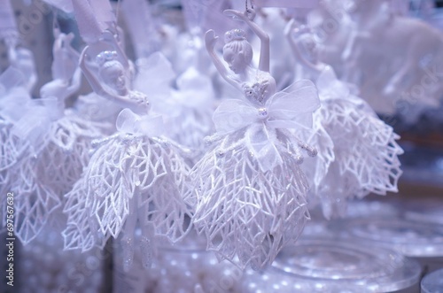 decorations for the Christmas tree in the form of figures of ballerinas in fishnet dresses on a shelf in a close-up in a hypermarket before Christmas